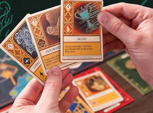 A player holding illustrated spell cards from the game